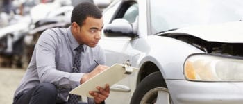 Loss Adjuster Inspecting Car Involved In Accident